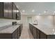 Open kitchen with granite countertops, stainless steel appliances, gray cabinets and tile floors at 6598 Lullaby Way, Mascotte, FL 34753
