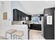 Modern kitchen with sleek black cabinets, stainless steel appliances, breakfast bar and white countertops at 720 N Pennsylvania Ave, Winter Park, FL 32789