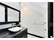 Bright bathroom features a vessel sink atop a black marble vanity, with chrome fixtures and white walls at 726 N Pennsylvania Ave, Winter Park, FL 32789