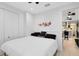 Calm bedroom featuring a white bed, wood floors, and a doorway to a kitchen area at 726 N Pennsylvania Ave, Winter Park, FL 32789