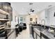 Open-concept kitchen and living area featuring modern stainless appliances and sleek black cabinetry at 726 N Pennsylvania Ave, Winter Park, FL 32789