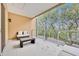 Outdoor balcony with glass railing and comfortable seating overlooking lush landscaping at 7663 Recife Dr, Kissimmee, FL 34747