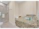 Bathroom features a granite vanity, a glass-enclosed shower and a neutral color palette at 7663 Recife Dr, Kissimmee, FL 34747