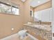 Modern bathroom featuring a stylish granite vanity and ample natural light at 7663 Recife Dr, Kissimmee, FL 34747