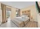 Comfortable bedroom with a king bed, bench, natural light, and neutral decor at 7663 Recife Dr, Kissimmee, FL 34747