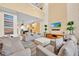 Open-concept living room featuring a spacious seating area, modern decor, and view into the kitchen at 7663 Recife Dr, Kissimmee, FL 34747