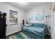Bright bedroom featuring hardwood floors, a blue daybed, a window with blinds, and colorful artwork at 8807 Tatara St, Orlando, FL 32836