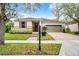 Charming home featuring a stone facade, tan siding, and a well-manicured lawn with a brick walkway and driveway at 8807 Tatara St, Orlando, FL 32836