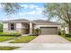 Charming home featuring a stone facade, tan siding, a two car garage, and a brick paver driveway at 8807 Tatara St, Orlando, FL 32836