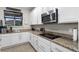 Modern kitchen featuring granite countertops, white cabinets and stainless steel appliances at 8807 Tatara St, Orlando, FL 32836