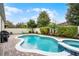 Inviting pool area with paver deck, white fence, lush landscaping, and comfortable seating, perfect for relaxation and entertainment at 8807 Tatara St, Orlando, FL 32836