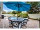 Outdoor patio with a table and chairs next to a pool surrounded by lush landscaping and a privacy fence at 8807 Tatara St, Orlando, FL 32836