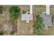 Bird's eye view of a home's roof and backyard, highlighting its compact layout and the surrounding greenery at 10 Pine Course Pass, Ocala, FL 34472