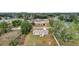 Aerial view of home and neighborhood with mature trees, grass, and fenced in backyard at 10 Pine Course Pass, Ocala, FL 34472