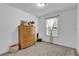 A simply decorated bedroom with a dresser, window, neutral carpet and wicker basket at 10 Pine Course Pass, Ocala, FL 34472