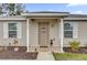 Inviting front door with covered porch, modern lighting, and lovely landscaping at 10 Pine Course Pass, Ocala, FL 34472