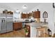 An inviting kitchen area featuring stainless steel appliances, breakfast bar, and wooden cabinets at 10 Pine Course Pass, Ocala, FL 34472