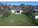 Aerial view of a home's backyard with a lush green lawn, a covered patio, and mature trees, perfect for outdoor living at 1107 Galway Blvd, Apopka, FL 32703