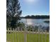 Picturesque lake view from the property, featuring a white picket fence in the foreground at 1107 Galway Blvd, Apopka, FL 32703