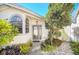 Home featuring a stone path, glass door, and an arched window, surrounded by lush landscape at 11278 Papyrus Ln, Orlando, FL 32821