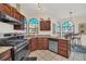 Well-lit kitchen features dark wood cabinets, granite countertops, stainless steel appliances, and a large arched window at 11278 Papyrus Ln, Orlando, FL 32821