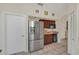 Kitchen featuring a stainless steel refrigerator, dark cabinets, and tiled floors at 11278 Papyrus Ln, Orlando, FL 32821