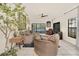 Bright living room featuring neutral furniture, tile floors, ceiling fan, and sliding glass doors to the pool at 11278 Papyrus Ln, Orlando, FL 32821