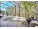 Relaxing screened pool area featuring lounge chairs, a table, and a tropical landscaped surround at 11278 Papyrus Ln, Orlando, FL 32821