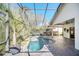 Enjoy a refreshing dip in this screened-in pool, surrounded by lush tropical plants at 11278 Papyrus Ln, Orlando, FL 32821