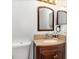 Bathroom with a dark wood vanity, stone countertop, stylish fixtures, decorative mirrors and a tile backsplash at 12100 Calaboose Ct, Orlando, FL 32828