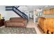 Cozy living room featuring a staircase with blue rails, a comfortable sofa, and an area rug at 12100 Calaboose Ct, Orlando, FL 32828