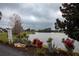 Scenic view of a pond with vibrant landscaping and a community sign in the background at 12100 Calaboose Ct, Orlando, FL 32828