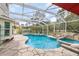 Beautiful screened pool with a spa, rock waterfall feature, and ample patio space at 12100 Calaboose Ct, Orlando, FL 32828