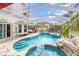 Sparkling screened pool and spa with a rock waterfall feature, perfect for outdoor relaxation at 12100 Calaboose Ct, Orlando, FL 32828