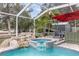 Inviting screened pool with rock waterfall feature and spa, surrounded by lush landscaping at 12100 Calaboose Ct, Orlando, FL 32828