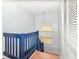 Staircase with blue painted railings and wooden stairs, illuminated by a pendant light and a window at 12100 Calaboose Ct, Orlando, FL 32828