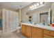 Bright bathroom features a large mirror, vanity with storage, and shower with seashell themed curtain at 1211 Stonecutter Dr # 304, Celebration, FL 34747