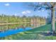 Picturesque pond view with the water reflecting blue sky and surrounding trees at 1211 Stonecutter Dr # 304, Celebration, FL 34747