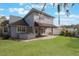 View of the home's backyard with a brick patio, covered seating area, and lush green grass at 1230 Mercedes Pl, Orlando, FL 32804