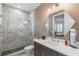 Bathroom featuring a walk-in shower with marble tiling, vanity, and a modern mirror at 1230 Mercedes Pl, Orlando, FL 32804