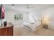 Bright bedroom featuring a white bed, bedside table, dresser, window, and neutral tones at 1230 Mercedes Pl, Orlando, FL 32804