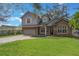 Charming two-story home with stone accents, attached two car garage, and expansive manicured lawn at 1230 Mercedes Pl, Orlando, FL 32804