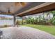 View of the covered brick patio highlighting lush landscaping and a green grassy lawn at 1230 Mercedes Pl, Orlando, FL 32804