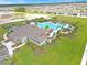 Aerial view of a community pool area, featuring mature palm trees and lounge chairs on a sunny day at 1239 Big Bass Dr, Ormond Beach, FL 32174