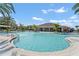 Community swimming pool featuring palm trees, fountains, lounge chairs, and umbrellas at 1239 Big Bass Dr, Ormond Beach, FL 32174