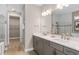 Bathroom featuring double sink vanity, quartz countertop, and a walk-in glass shower at 13684 Fresh Ivy St, Winter Garden, FL 34787