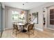 Sunlit dining area with modern light fixture and view of the landscaped backyard at 13684 Fresh Ivy St, Winter Garden, FL 34787