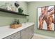 Charming laundry room featuring modern gray cabinets, light countertops, decorative accents, artwork, and tile floors at 13684 Fresh Ivy St, Winter Garden, FL 34787