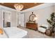 Stylish main bedroom with wood ceiling, wood dresser, accent chair, and ensuite bathroom at 13684 Fresh Ivy St, Winter Garden, FL 34787