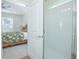 Bright bathroom featuring a glass enclosed shower and view of a bedroom with floral bedding at 14250 Lanikai Beach Dr, Orlando, FL 32827